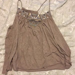 Beige tank with embroidered detail on top.